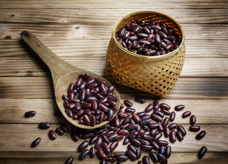 Red bean in ladle and basket on the wood backgroundの写真素材