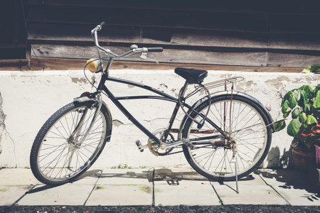 Old black bicycle with house wall background
