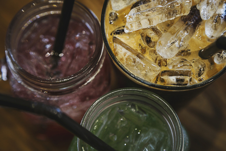 Iced coffee with cream and Italian soda  in glass on the woodの写真素材