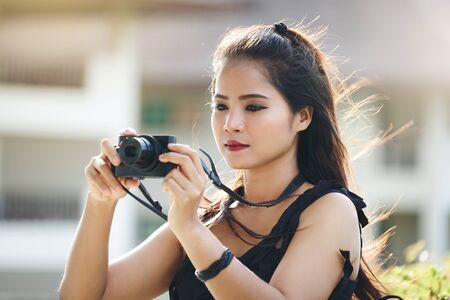 beautiful woman photographer with a compact camera taking photosの写真素材