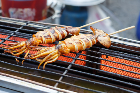 Grilled Squid on grill, cooking at market thailandの写真素材