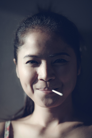 Beautiful cute girl she happy smiley and she eat dessert, candy. with lighting contrastの写真素材