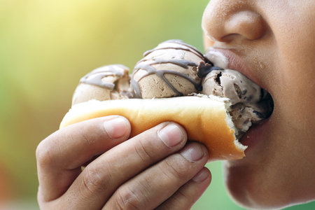 Children are eating bread and ice cream topped with chocolate sauce Letterman. Ice cream with a...
