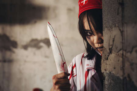 Nurse uniform killer Hold the knife and peek At an abandoned hospitalの写真素材