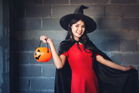 The witch girl dress up Halloween Party And she holds a pumpkin in her hand