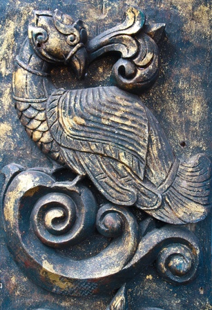 Old wood carvings of birds on the black gold.の写真素材