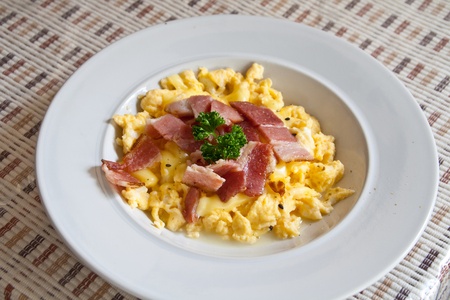Roasted egg, sprinkle with bacon on white dish.の写真素材