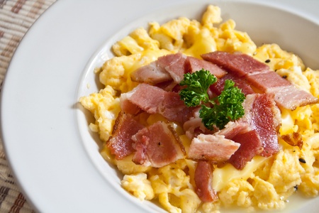 Roasted egg, sprinkle with bacon on white dish.の写真素材