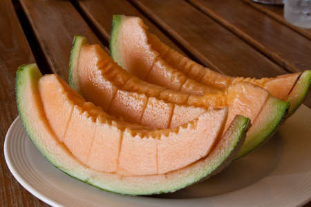 Yellow melon piece on a white plate.の写真素材