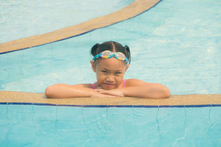 Girl in the swimming pool in the daylight.の写真素材