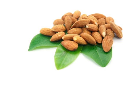 Almonds on green leaf and white background の写真素材