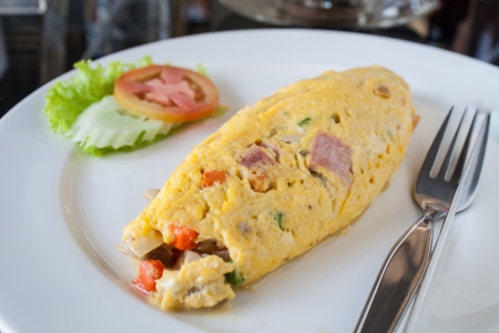 Garnish with cucumber, tomato, egg rolls, ham on white dish の写真素材