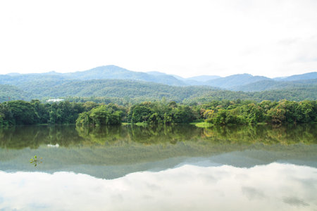 Mountains, trees, the sky reflected on water の写真素材