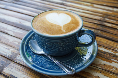 Hot coffee drawing hearts in blue glass.