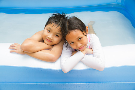 Kids play swim in inflatable plastic pool.の写真素材