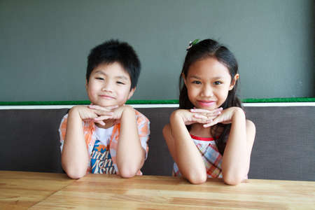 Boys and girls smiling sitting in a restaurant.の写真素材
