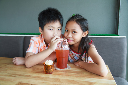 Boys and girls drinking ice tea in a restaurant.の写真素材