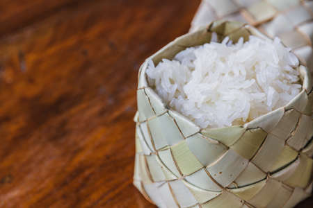 Sticky rice in bamboo box on wooden table.の写真素材