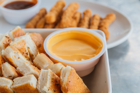 Chicken stick and bread stick with sauce on white plate.の写真素材