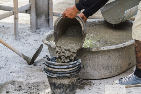 Workers put in a bucket of cement.