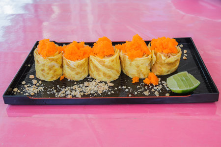 Sushi rice roll egg with eggs shrimp in black plate on restaurant.の写真素材