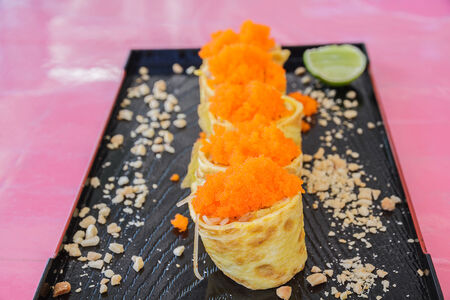 Sushi rice roll egg with eggs shrimp in black plate on restaurant.の写真素材