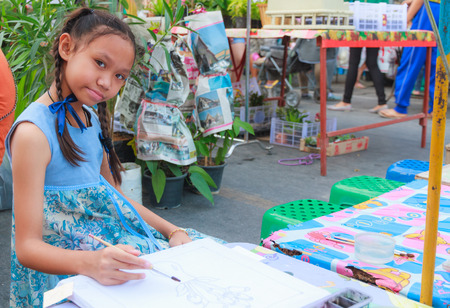 Asian girl painting flower vase on canvas painting.の写真素材