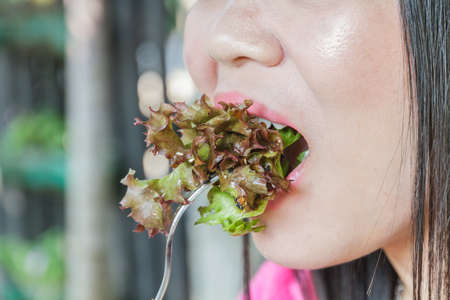 Asia woman eating salad vegetable in restaurant.の写真素材
