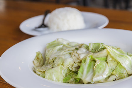 Cabbage stir fish sauce on white plate in restaurant.の写真素材