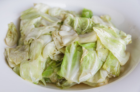 Cabbage stir fish sauce on white plate in restaurant.の写真素材