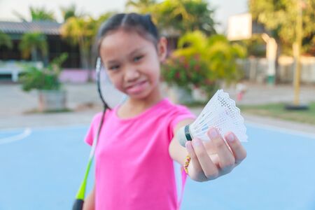 Cute little girl holding badminton racket and shuttlecock, Outdoor.の写真素材