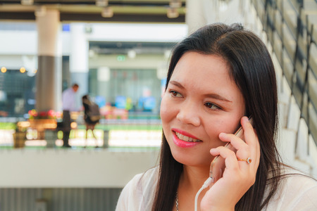 Happy asian woman is using smartphone to communication.の写真素材