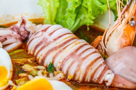 Thai local food: Noodles seafood spicy is Hot noodles add squid, shrimp, egg and meat ball.の写真素材
