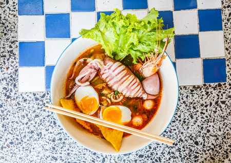 Thai local food: Noodles seafood spicy is Hot noodles add squid, shrimp, egg and meat ball.の写真素材