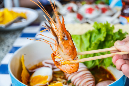 Thai local food: Noodles seafood spicy is Hot noodles add squid, shrimp, egg and meat ball.の写真素材