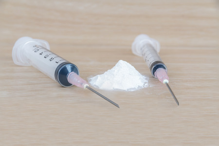 Drugs: Syringe and heroin on wood table.の写真素材