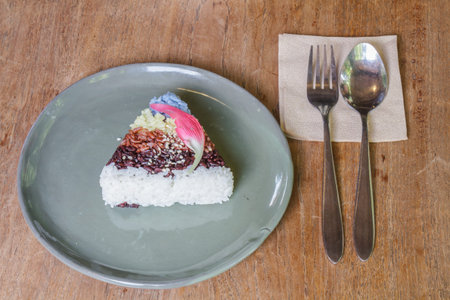 Rice five color in plate and silverware on wood table.