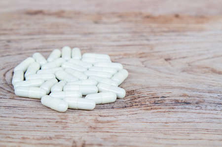 Pill drug yellow capsule on wood table.の写真素材