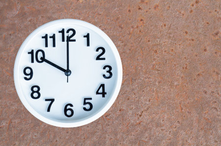 Clock show 10 am or pm on steel rusty background with copy space.