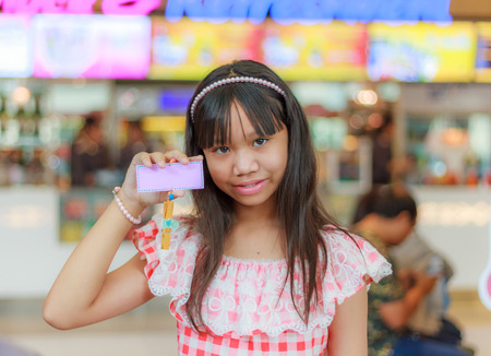 Asian child girl show mark wood at shopping mall with copy space.の写真素材