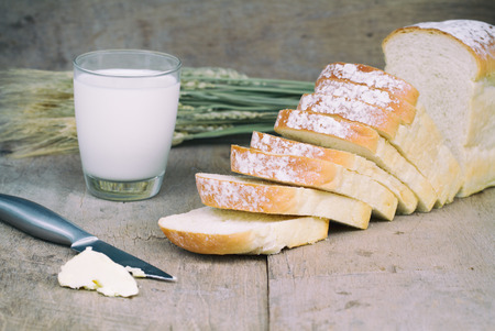 Bread and milk and butter on wood table. Retro style.の写真素材