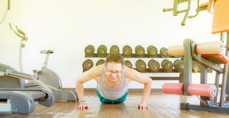 Asia man middle aged push up in the gym for strength, weight loss.