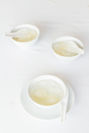 Rambutan in syrup in white cup and saucer on table at restaurant.の写真素材