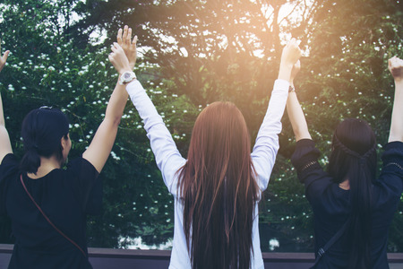 Asia teenage three girls glad hands in nature. Selective focus and soft flare sunlight.の写真素材