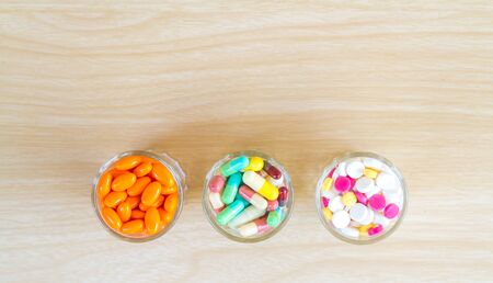 Medicine is pill and capsule in glass with copy space on wood table. top view.の写真素材