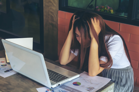 Asia girl use laptop emotion edgy or busy or anxiety due to work or education.の写真素材