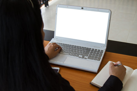 Teenage freelance working business on laptop. The blank screen monitor with copy space for your text or advertising content. Selective focus and soft flare filter. Clipping path in picture.の写真素材