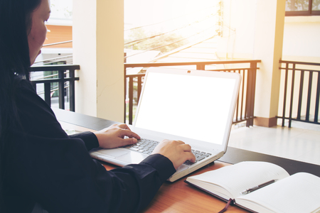 Teenage freelance working business on laptop. The blank screen monitor with copy space for your text or advertising content. Selective focus and soft flare filter. Clipping path in picture.の写真素材