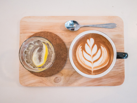 Hot coffee drawing heart in blue cup on wood texture.の写真素材