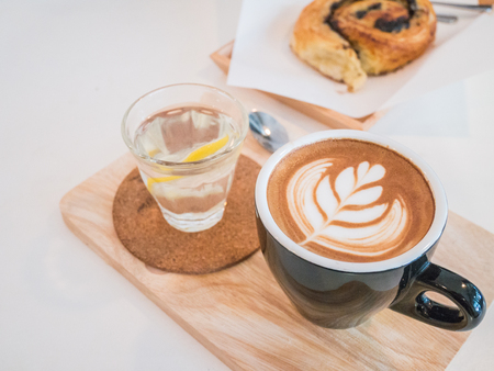 Hot coffee drawing heart in blue cup on wood texture.の写真素材